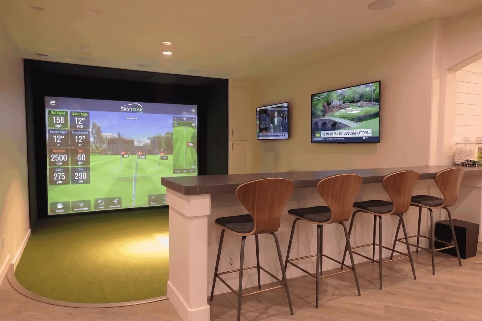 Custom luxury indoor residential golf simulator room in St. Petersburg, Florida, featuring a high-fidelity projection screen, integrated home wet bar, and tour-grade synthetic putting turf.