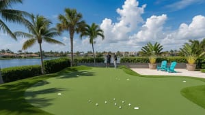 Seminole Backyard Putting Green Lawn Replacement - Sims & Greens Luxury backyard artificial turf putting green next to a swimming pool and palm trees in Seminole, Florida.
