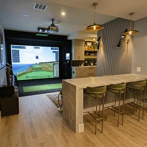 custom-garage-golf-simulator-installation-st-petersburg-fl - Sims & Greens A luxury indoor golf simulator room A custom residential garage completely converted into a high-end indoor golf simulator studio in St. Petersburg, Florida, featuring an edge-to-edge impact screen, premium artificial turf flooring, and professional acoustic treatments. Clearwater, Florida, featuring a custom-built granite entertainment bar with seating, perfectly positioned behind the hitting area and impact screen for premium home entertaining.
